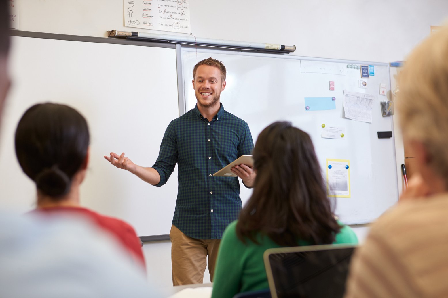 a person standing in front of a whiteboard with their hands in the air